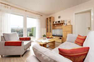 a living room with white furniture and a large window at Ferienhaus Schneider- Snieder&#039s Hoeg in Lenste
