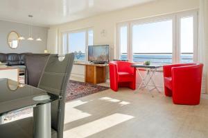 - un salon avec des chaises rouges et une table avec une télévision dans l'établissement Haus Seestern Grömitz Strandzauber, à Grömitz 34 autres photos