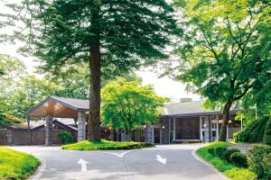 a building with a tree in the middle of a street at Karuizawa Prince Hotel West in Karuizawa