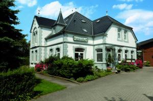 a white house with a black roof at Hotel & Restaurant Villa Ulmenhof in Bredstedt