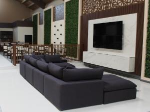 a living room with a large couch and a tv at Hangar Inn TJ - Aeropuerto in Tijuana