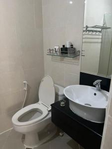a white bathroom with a toilet and a sink at Spacious 2 Bed & 2 Bath Condo in Newport City in Manila +14 photos