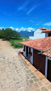 a building with a tile roof and a patio at AQUI ESTOY BIEN in Barichara