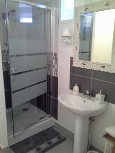 uma casa de banho com um chuveiro, um lavatório e um espelho. em Le Coq En Pate em Péronne