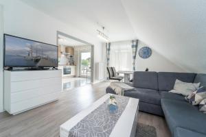 a living room with a couch and a tv at Blankwasserweg 16- Sonnenseite in Grömitz