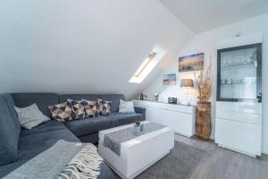 a living room with a couch and a tv at Blankwasserweg 16- Sonnenseite in Grömitz