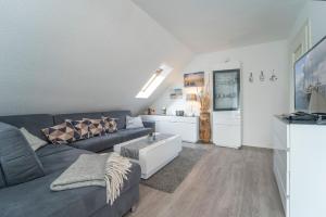 a living room with a couch and a table at Blankwasserweg 16- Sonnenseite in Grömitz