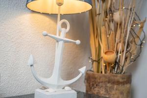 a wooden anchor on a table next to a lamp at Blankwasserweg 16- Sonnenseite in Grömitz +23 photos