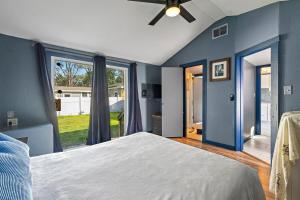 una camera blu con un letto e una grande finestra di Guest House By Pinellas Trail,BeachGear,Parking a St Petersburg