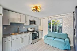 una cucina con mobili bianchi e una sedia blu di Guest House By Pinellas Trail,BeachGear,Parking a St Petersburg