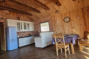 a kitchen with a table and a clock on the wall at Holiday homes with a private beach on the lake in Grąbczyn