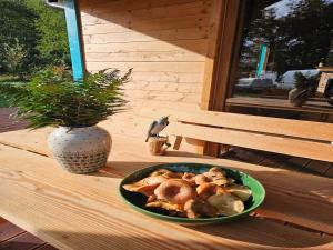 a plate of food on a table with a vase at Holiday homes with a private beach on the lake in Grąbczyn +25 photos