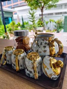 a tray with a group of vases on a table at Green Garden House กรีนการ์เด้นเฮ้าส์ นครพนม in Nakhon Phanom