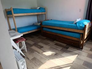 a bedroom with two bunk beds and a wooden floor at Posada Camet in Camet Norte