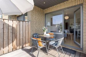 a patio with a table and chairs on a deck at Blankwasserweg 131 Lensterstrand Oase Bungalow 6 in Lenste