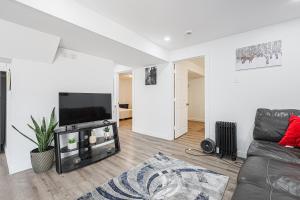 Una sala de estar con un sofá y un televisor de pantalla plana. en Exquisite 2-Bedroom Guest Suite with FREE Parking, en Bradford