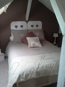Un dormitorio con una cama con un cartel. en Le Coq En Pate, en Péronne