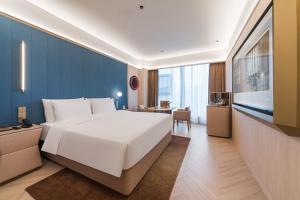 Postel nebo postele na pokoji v ubytování Guangzhou Olympic Sports Centre Financial City Crystal Orange Hotel