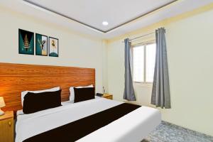 a bedroom with a large bed and a window at Hotel O Madlen in Hyderabad