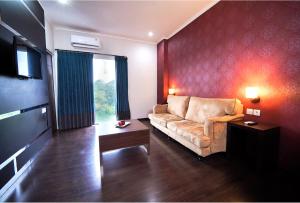 a living room with a couch and a television at Noola Hotel Cilacap in Gumilir