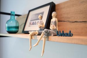 a couple of dolls sitting on a shelf at Haus Meeresgruß Ostseebrise in Grömitz