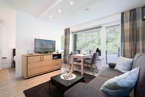 a living room with a couch and a tv and a table at Haus Meeresgruß Ostseebrise in Grömitz