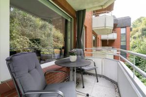 a balcony with two chairs and a table on a balcony at Haus Meeresgruß Ostseebrise in Grömitz +19 photos