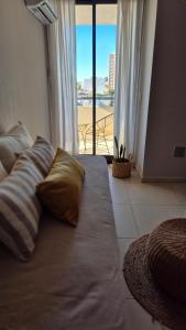 een bed met kussens in een kamer met uitzicht bij La Riviera MARÍA II - CON COCHERA in Villa María +15 foto's