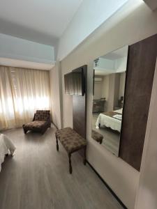 une chambre avec un miroir, un canapé et un lit dans l'établissement Aires del Libertador - Alquiler Temporario en Centro San Francisco, à San Francisco