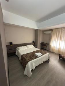 une chambre avec un grand lit et une table dans l'établissement Aires del Libertador - Alquiler Temporario en Centro San Francisco, à San Francisco