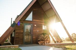 a log cabin with a door and a pile of wood at Skyfarm Retreat in Cradoc +17 photos