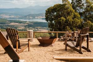 two wooden chairs sitting on top of a hill at Skyfarm Retreat in Cradoc