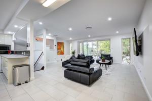 a large living room with black furniture and a kitchen at Lakeview Family Retreat Canberra Cozy Townhouse in Gungahlin