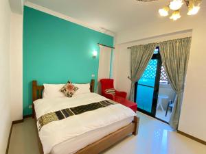 a bedroom with a bed and a blue wall at 花蓮觀月民宿-近車站-寵物友善-含車位可包棟8-14位 烤肉麻將僅提供給包棟使用 in Hualien City