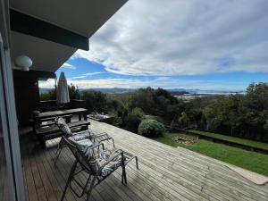 a deck with two chairs and a piano on a house at The Grays in Whangarei