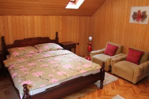 a bedroom with a bed and two chairs at Holiday Home Zbilje in Visoko