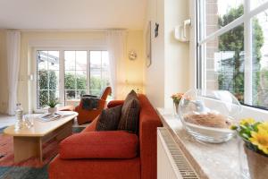 a living room with a red couch and a table at Ferienhaus 17a in Kellenhusen