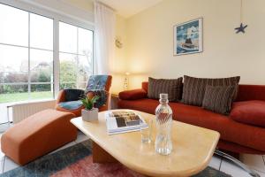 a living room with a red couch and a table at Ferienhaus 17a in Kellenhusen