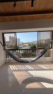 a hammock in a room with a view of a city at Apartamento Familiar en Rodadero in Rodadero +7 photos