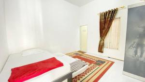 ブキティンギにあるVilla Palacios Syari'ah Bukittinggiのベッドルーム1室(赤い毛布付きのベッド1台付)