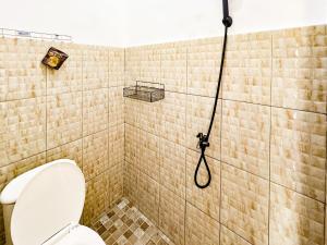 Un baño con ducha y WC. en Graha Indah Ngagel Surabaya RedPartner, en Surabaya 27 fotos más
