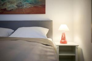 a bed with a table with a lamp on it at Promenade 18 Strandkrabbe in Stakendorfer Strand