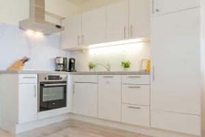 a white kitchen with white cabinets and appliances at Panoramic Panoramablick Ostsee in Hansaland