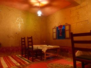 a dining room with a table and two chairs at Auberge Amazigh in Tamtetoucht