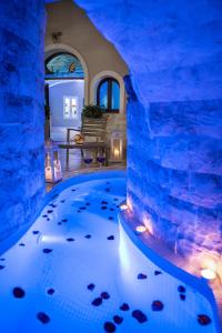 un acuario interior en una casa con una habitación iluminada con luz azul en Suite Home Santorini, en Fira