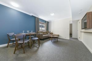 a dining room with a table and chairs and a couch at Spacious One-Bedroom or Studio with Balcony in Sydney