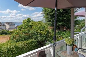 a table with an umbrella on a balcony with a view at Seepferdchen Blomen in Hansaland