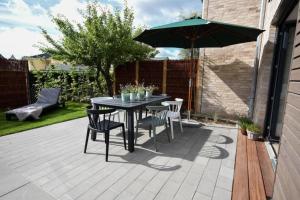 a patio with a table and chairs and an umbrella at Heimathafen Dahme in Dahme
