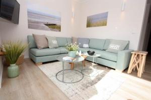 a living room with a blue couch and a table at Heimathafen Dahme in Dahme