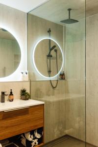 a bathroom with a shower and a sink and a mirror at Golden Bay Beach Retreat in Parapara 